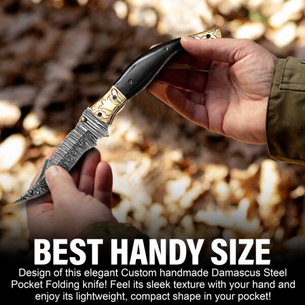 Compact Damascus steel folding pocket knife with black horn handle held in hand for everyday carry.