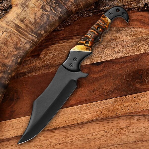 Close view of handmade carbon steel hunting knife with fire bone handle on wooden surface