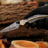 Handmade Damascus steel folding pocket knife held in hand, perfect gift for him and everyday carry.