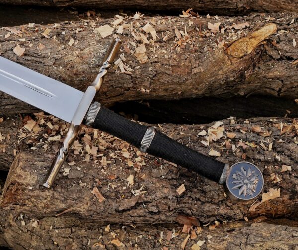 Handmade Witcher 3 inspired fantasy long sword with wall mount made from J2 steel displayed on wooden logs