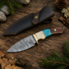Handmade Damascus steel knife with leather sheath outdoors