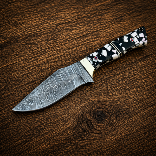 Custom Damascus steel knife with resin handle on wooden table