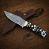 Handmade Damascus hunting knife with leather sheath on wooden background