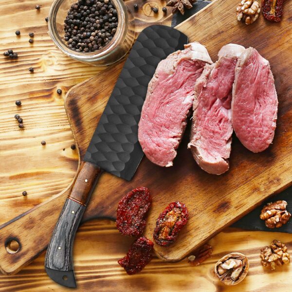 Handmade black forged meat cleaver slicing beef on a wooden cutting board. Professional high-carbon steel kitchen knife, gift for chef, husband, anniversary, Father's Day, and Christmas.