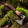 Rustic Viking hatchet with leather wrapped handle displayed outdoors