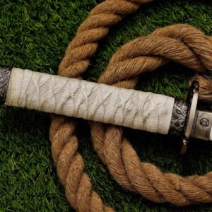 Close-up of white wrapped handle and decorative metal fittings on stainless steel sword