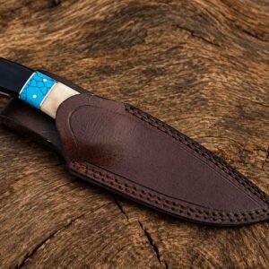 Damascus skinner knife partially shown with handcrafted brown leather sheath