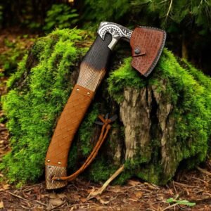 Home Viking-style handmade axe with leather-wrapped handle and decorative engraved head displayed on a moss-covered tree stump