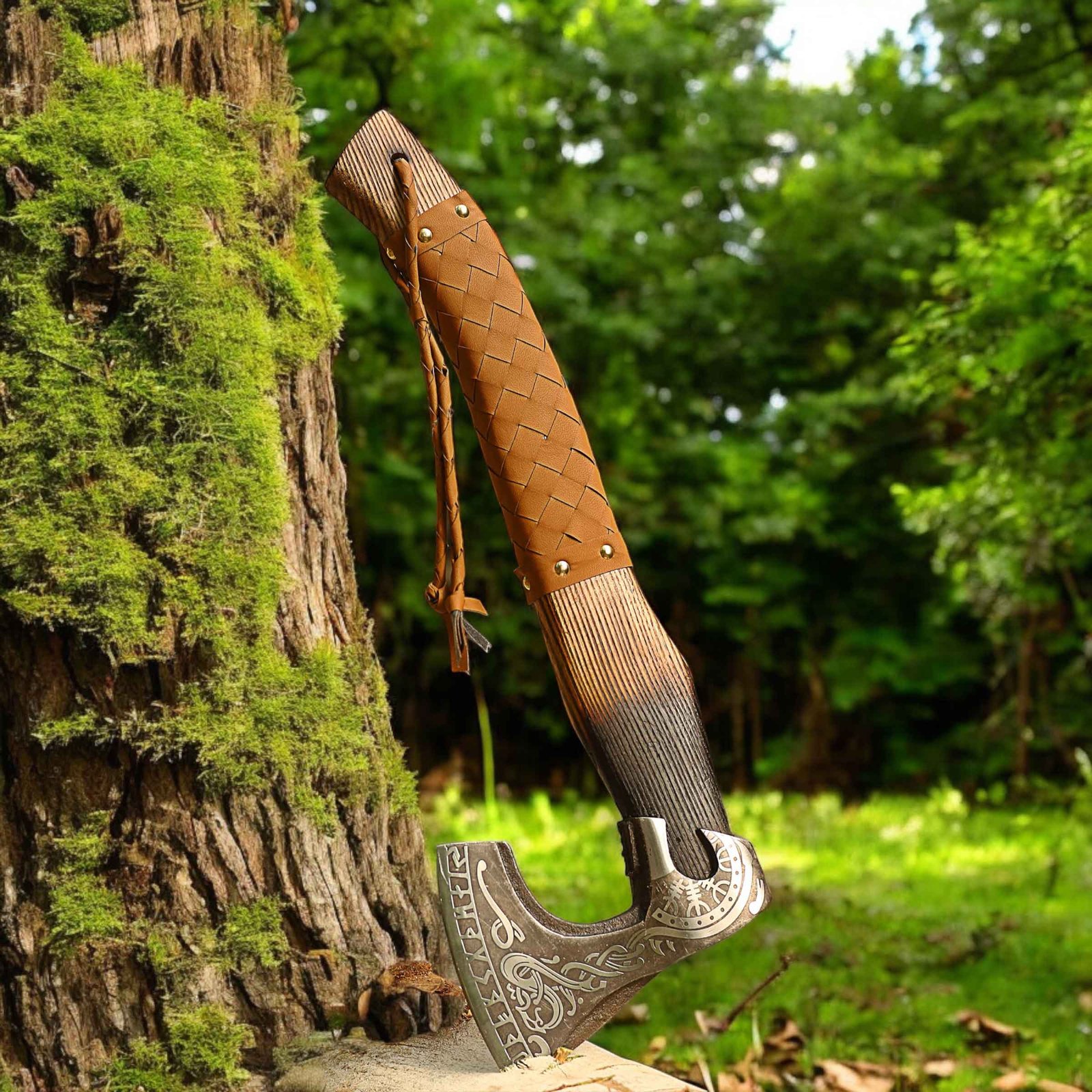 Leather-covered Viking axe displayed against a moss-covered tree in a green forest